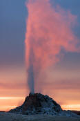 Image of White Dome Geyser erupting as sunset, Yellowstone National Park.