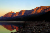 Image of sunrise on Altyn Mountain reflected in Swiftcurrent Lake in Glacier.