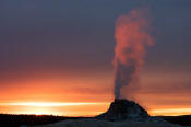 Image of White Dome Geyser erupting at sunset, Yellowstone National Park.